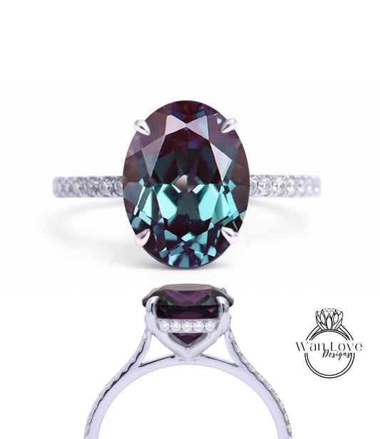 a stunning engagement ring with a large oval-shaped gemstone set in a silver band. The gemstone has a deep purple hue and is surrounded by smaller diamonds, creating a striking and elegant design.