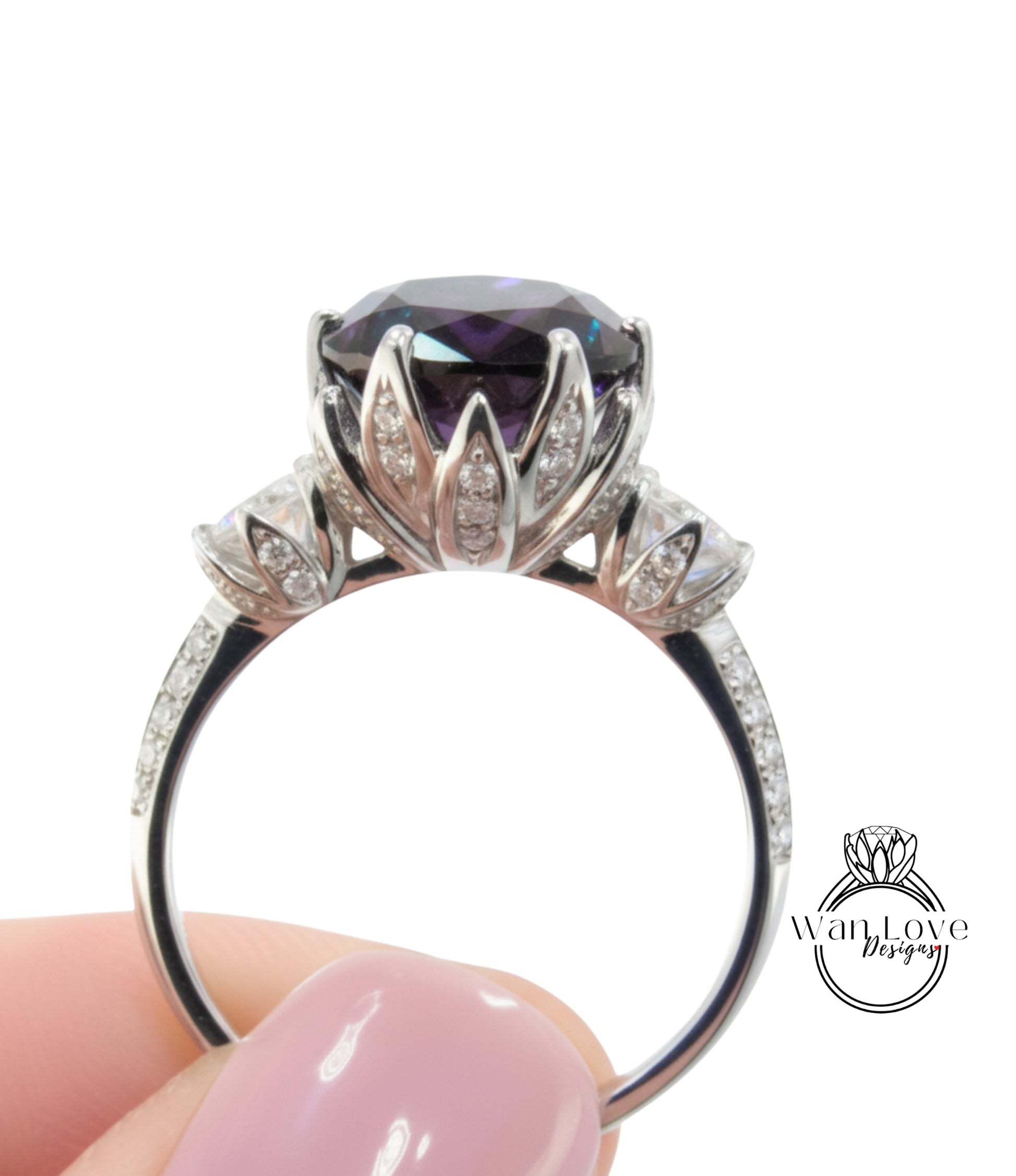 A close-up image of a person's hand holding a silver ring with a large purple gemstone, likely an engagement or wedding ring.