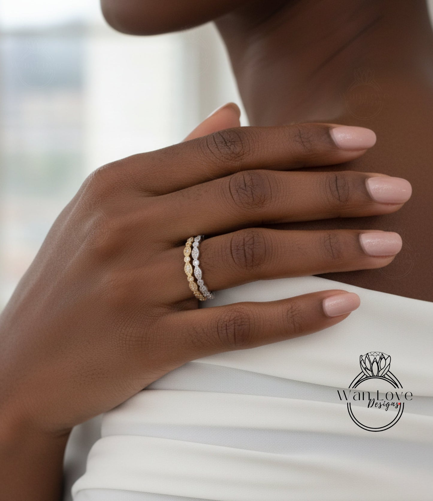 A close-up of a person's hand wearing a gold and white ring on the ring finger.