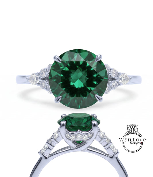 A stunning green gemstone engagement ring with a silver band and diamond accents.