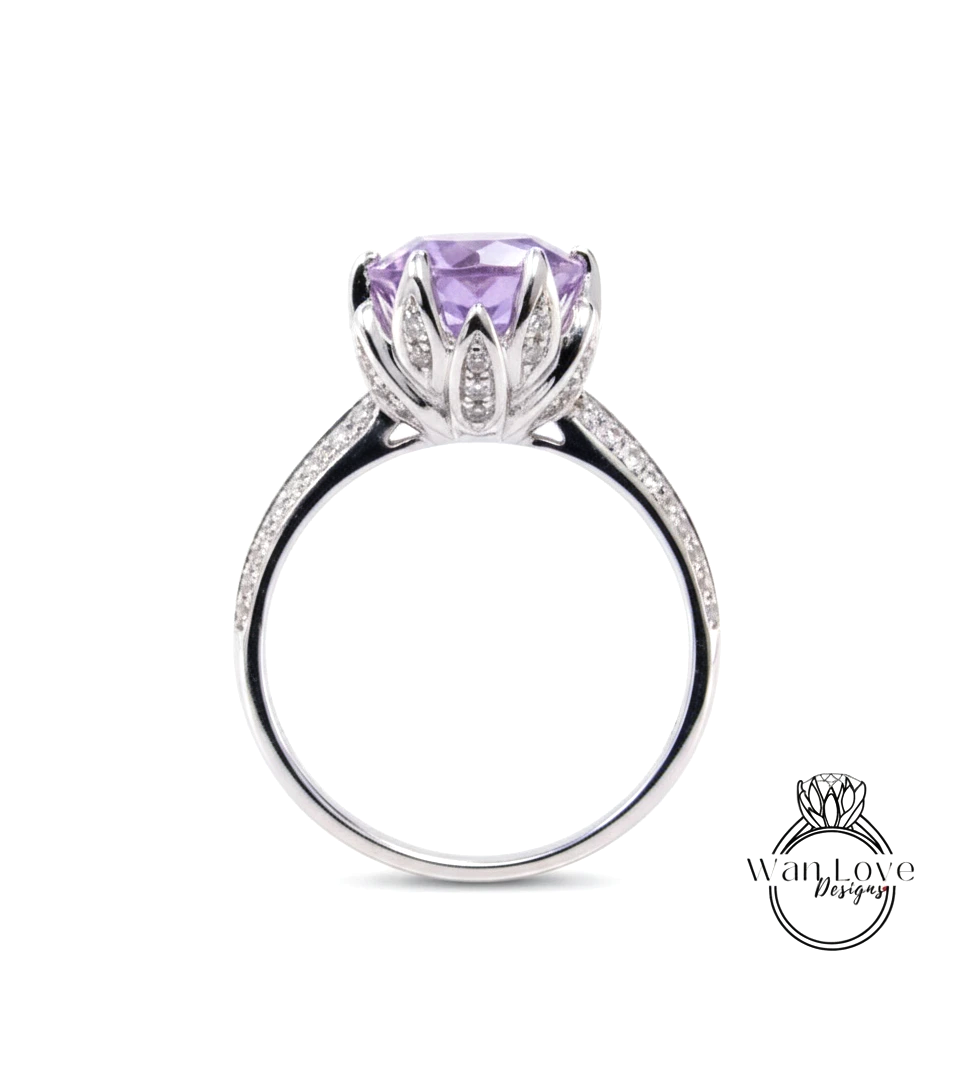 A silver ring with a large purple gemstone, likely a purple sapphire, set in a flower-like design.