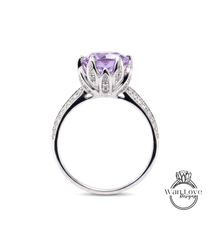 A silver ring with a large purple gemstone, likely a purple sapphire, set in a flower-like design.