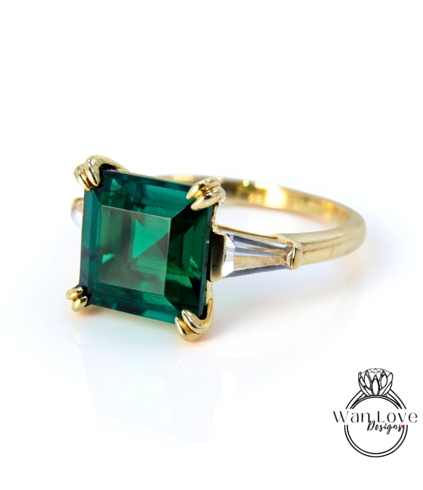 A gold ring with a large, square-cut green gemstone, possibly an emerald, set in a gold band.