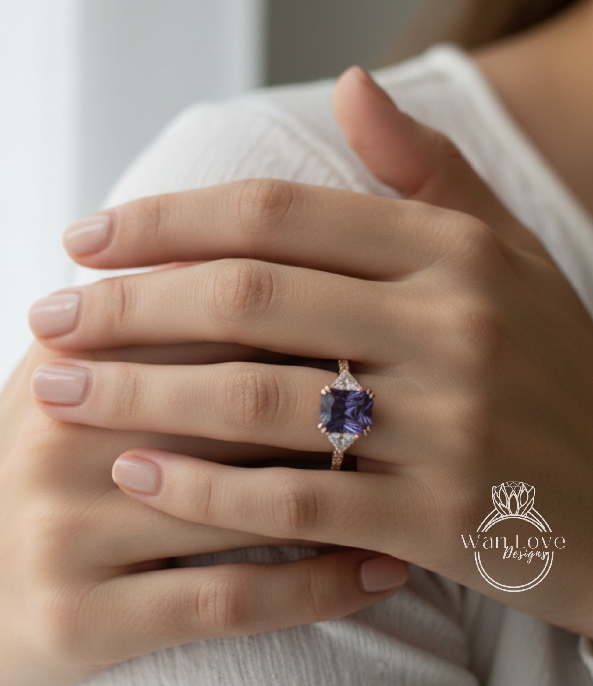A close-up image of a person's hand wearing a ring with a large purple gemstone.