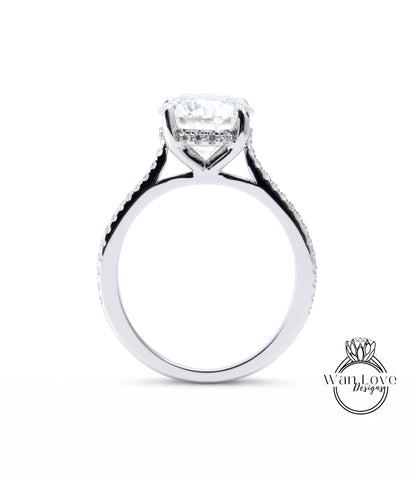 A close-up view of a silver engagement ring with a large central diamond and a halo of smaller diamonds around the center stone.
