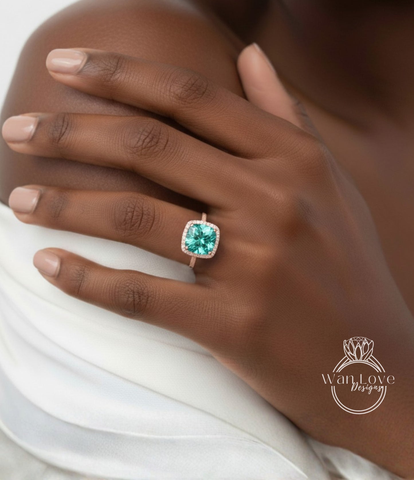 A close-up of a person's hand wearing a ring with a large, green gemstone.