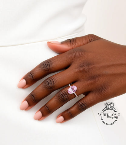A close-up of a hand wearing a ring with a pink gemstone.