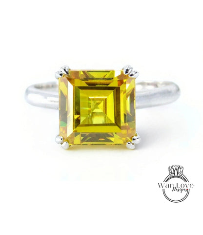 A ring with a large, square yellow gemstone set in a silver band.