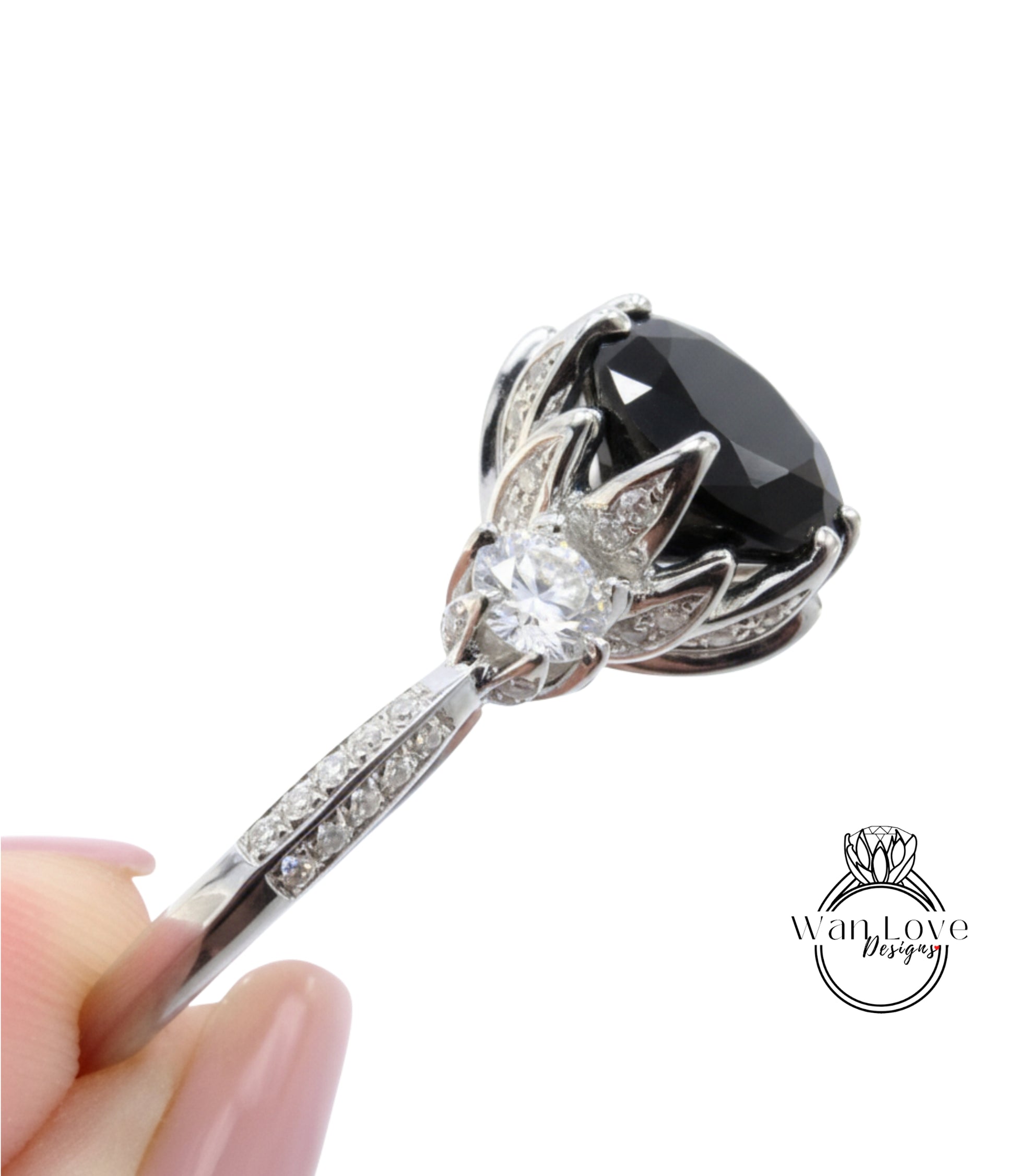 A close-up view of a diamond engagement ring with a large black gemstone and a smaller clear gemstone.