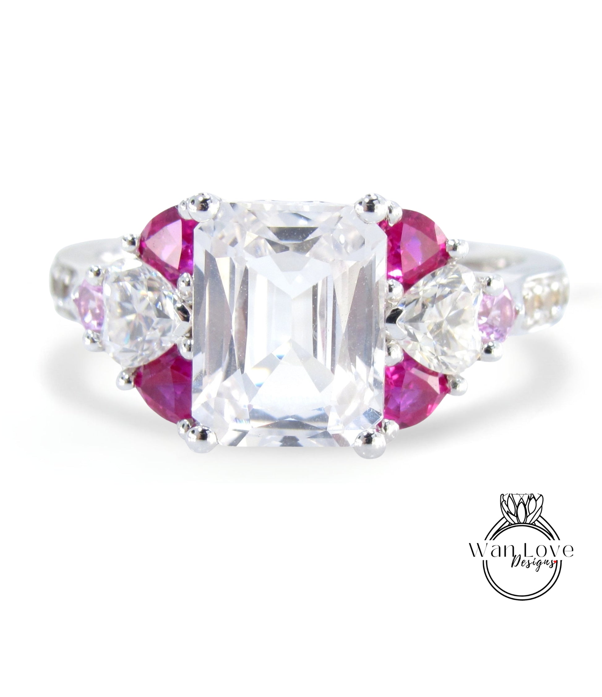 A close-up image of a diamond engagement ring with a large central diamond surrounded by smaller diamonds and gemstones in various colors, including pink and clear gemstones.