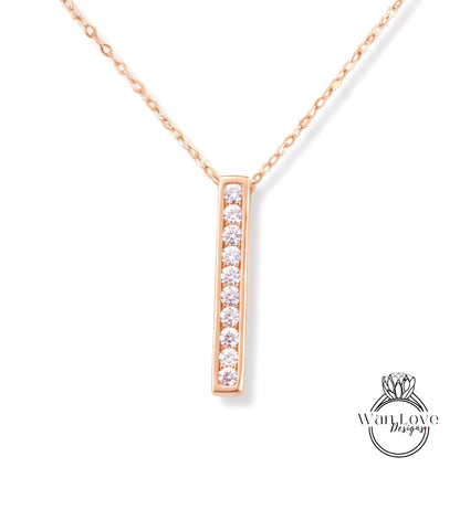 A delicate gold necklace with a single, rectangular pendant featuring a row of small diamonds.