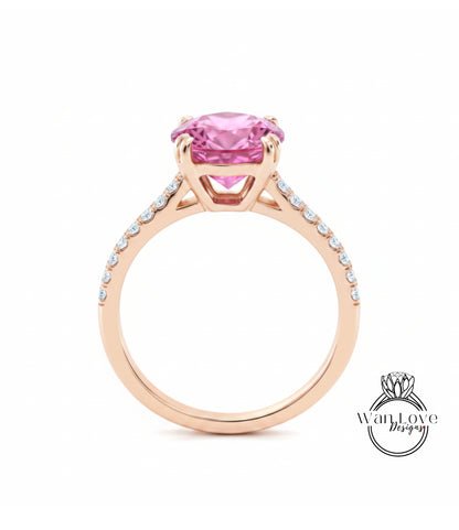 A gold ring with a large pink gemstone, likely a pink diamond, set in the center.