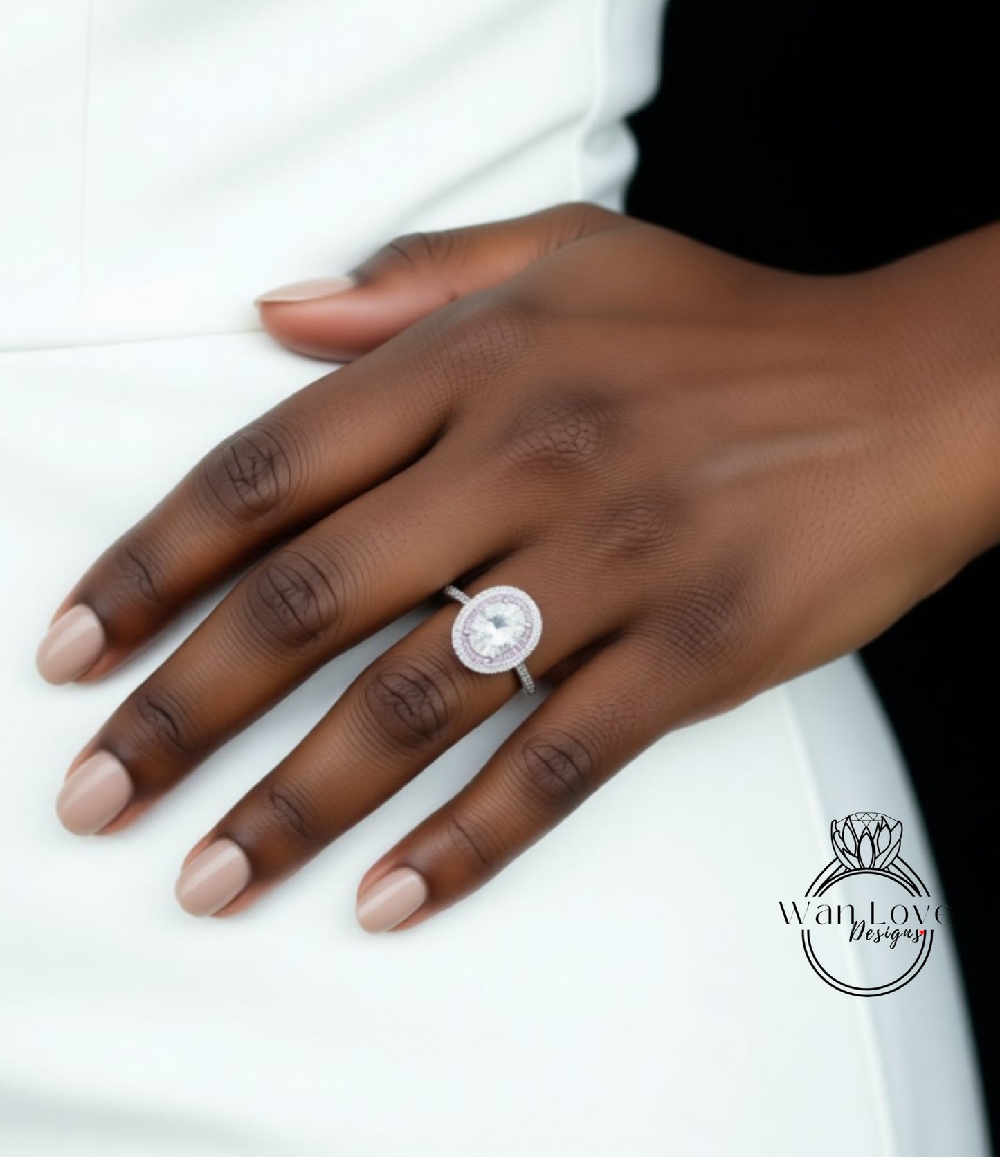 A close-up of a hand wearing a diamond ring on the ring finger.