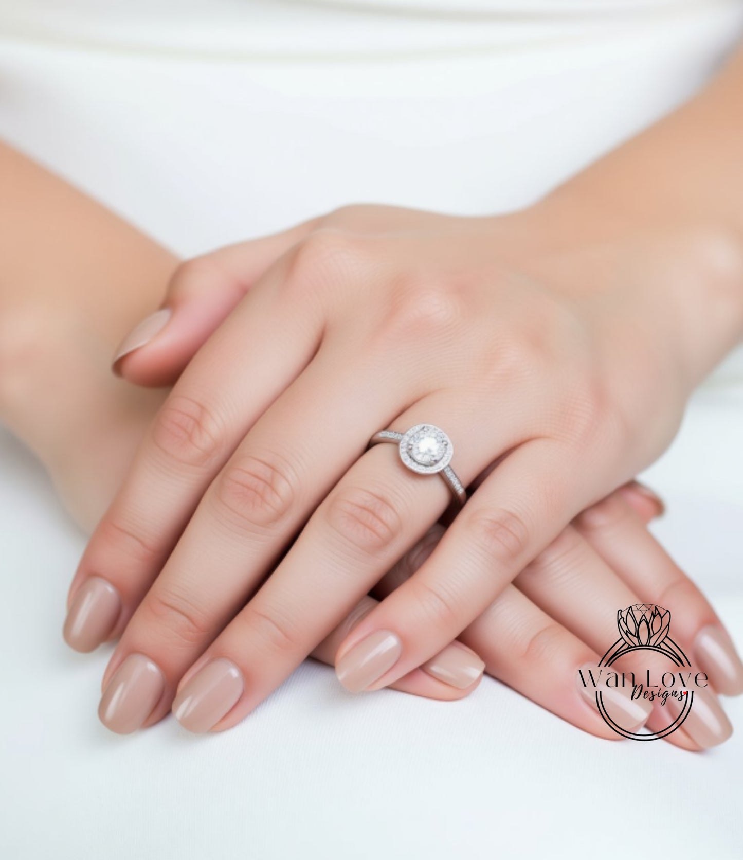 A close-up image of a person's hands wearing a diamond engagement ring.