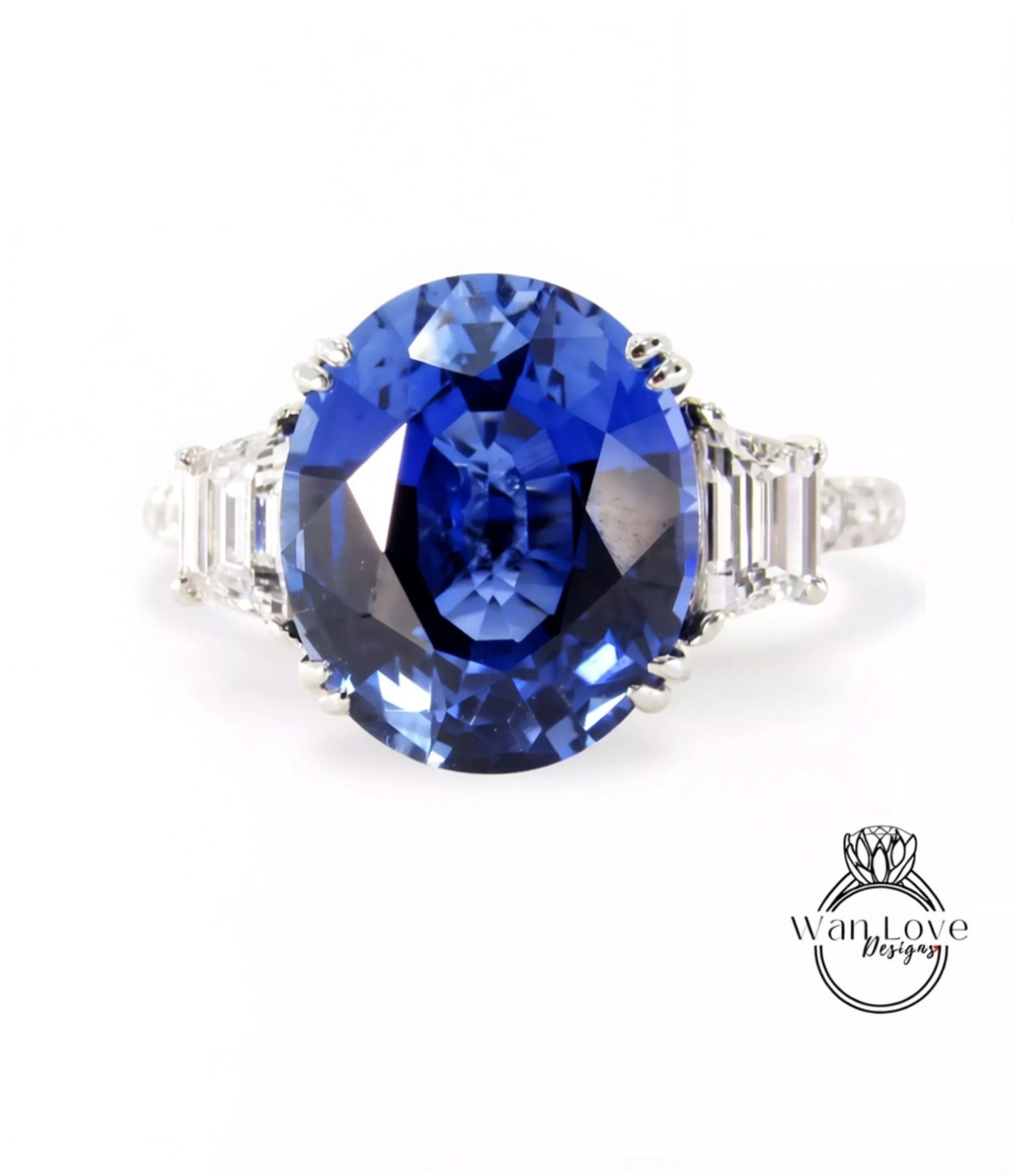 A stunning blue sapphire engagement ring with a large central stone surrounded by smaller stones on either side.
