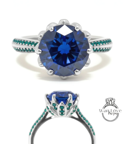 A stunning blue diamond engagement ring with a large central gemstone surrounded by smaller stones in green and silver. The ring is set in a silver band with a scalloped edge and a floral design.