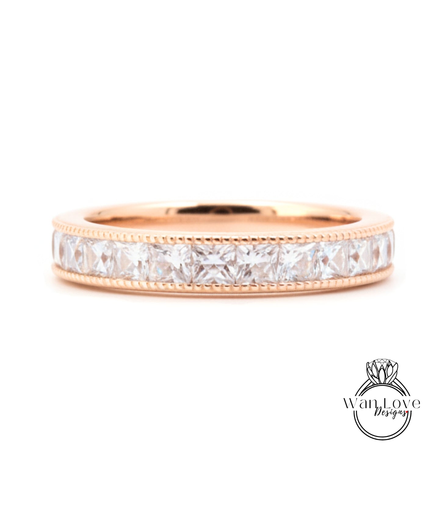 A gold band ring with a row of clear gemstones, likely diamonds, set in a rose gold band.