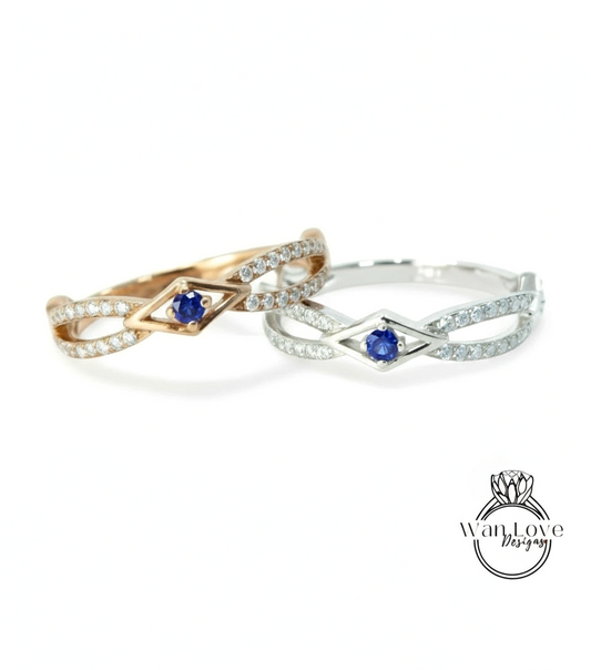 two rings with a blue gemstone, one in gold and one in silver, both featuring a diamond-encrusted design.