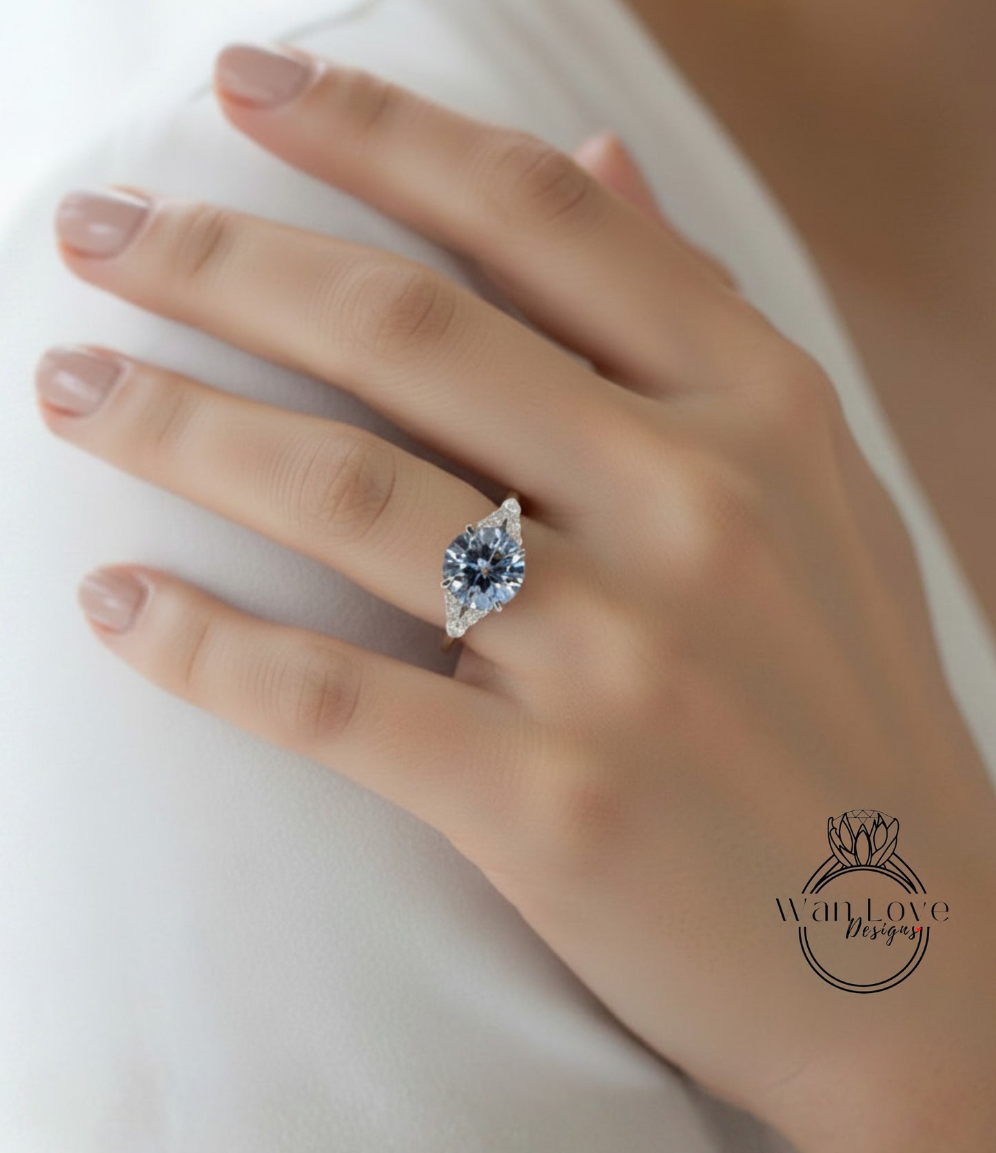 A close-up of a person's hand wearing a diamond engagement ring.