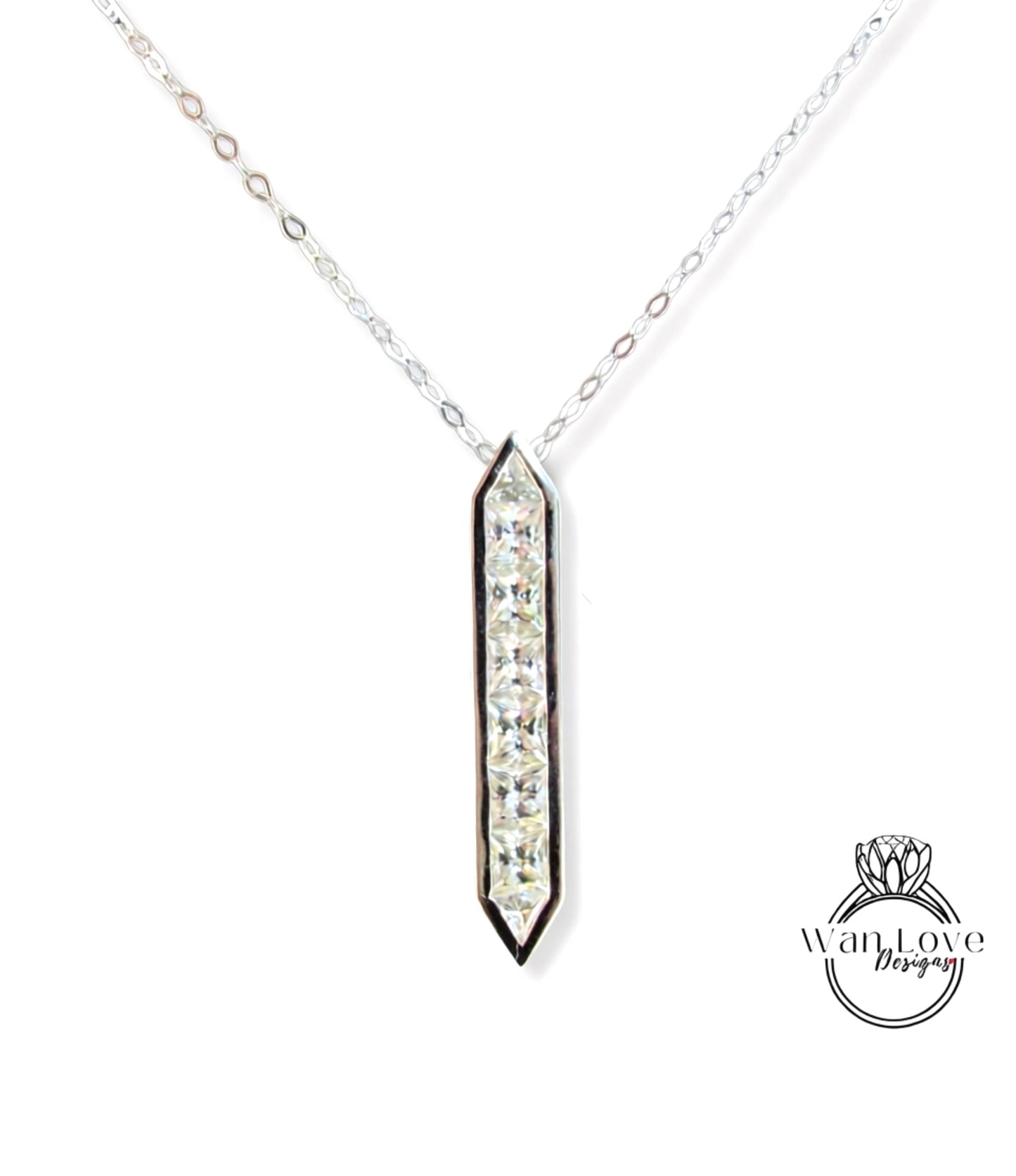 A silver necklace with a pendant featuring a row of clear gemstones.