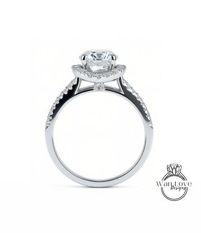 A silver engagement ring with a large central diamond and smaller diamonds on either side of the halo.