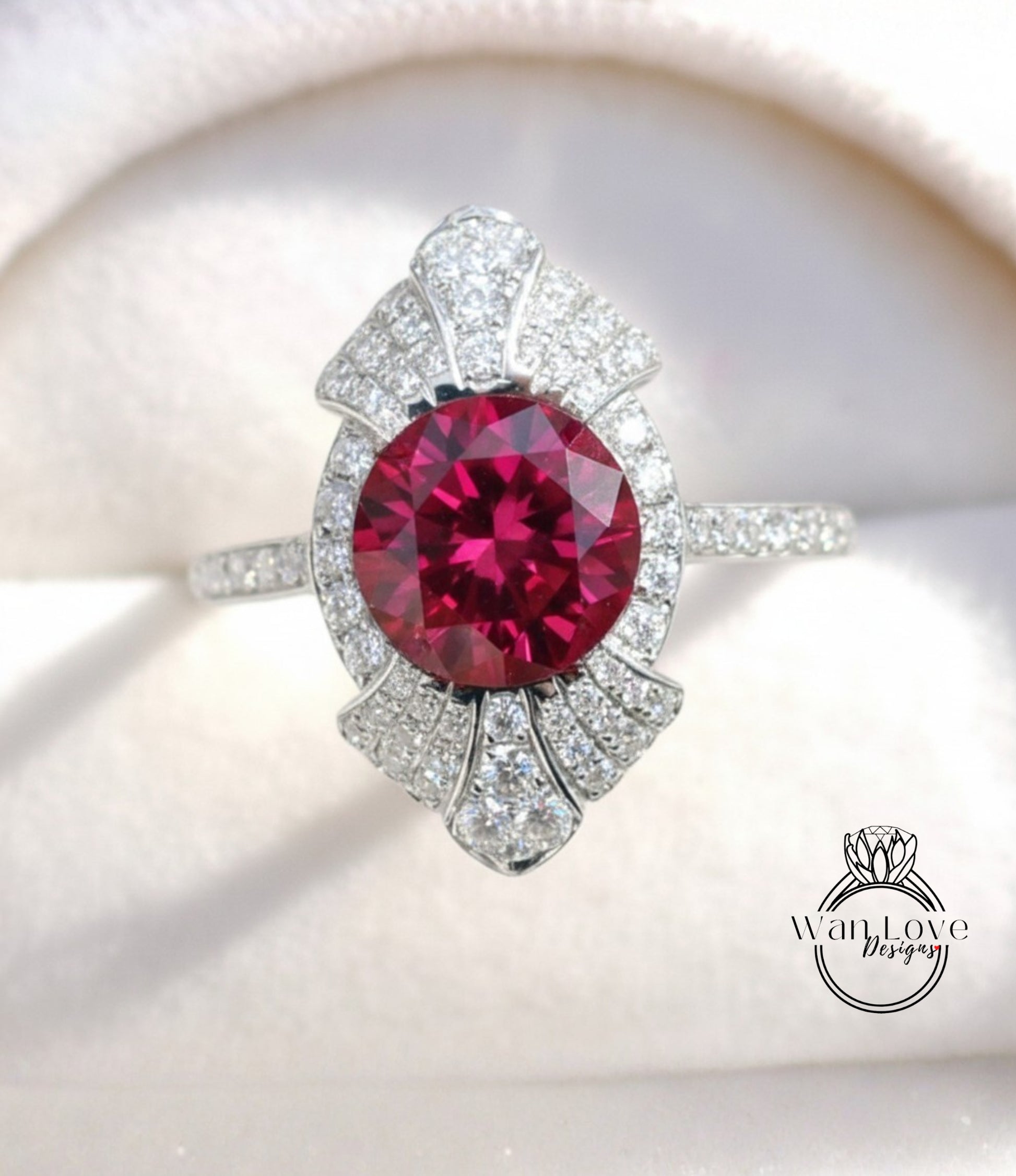 A close-up image of a stunning ring featuring a large, deep red gemstone surrounded by a sparkling diamond-encrusted band.