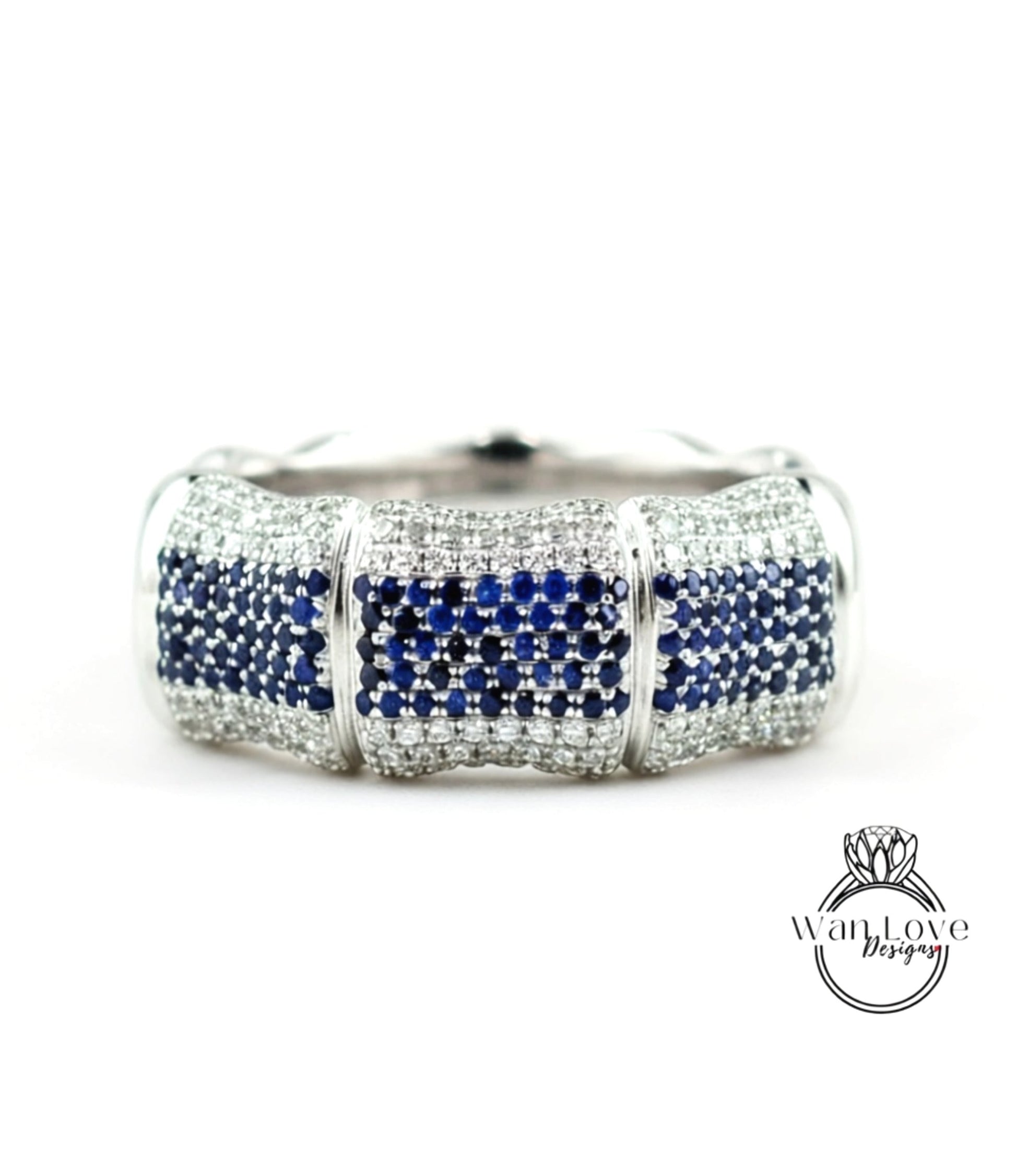 A silver and blue diamond bracelet with a large central diamond surrounded by smaller diamonds on either side.