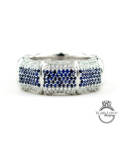 A silver and blue diamond bracelet with a large central diamond surrounded by smaller diamonds on either side.