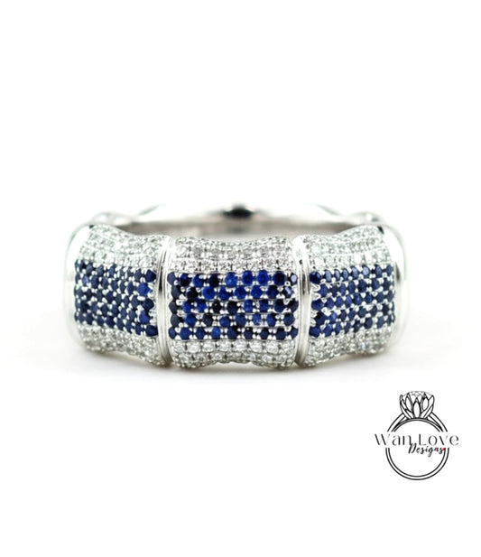 A silver and blue diamond bracelet with a large central diamond surrounded by smaller diamonds on either side.