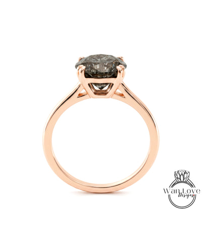 A rose gold engagement ring with a large, dark grey diamond set in the center.