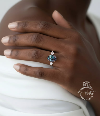 A close-up of a person's hand wearing a ring with a blue gemstone, resting on a white fabric.
