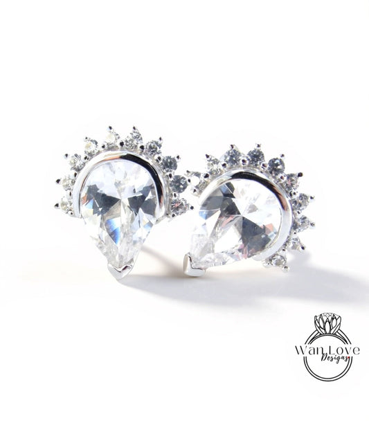 two elegant earrings with large, clear gemstones set in a decorative metal frame.