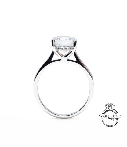 A silver engagement ring with a large, clear gemstone set in the center of the band.