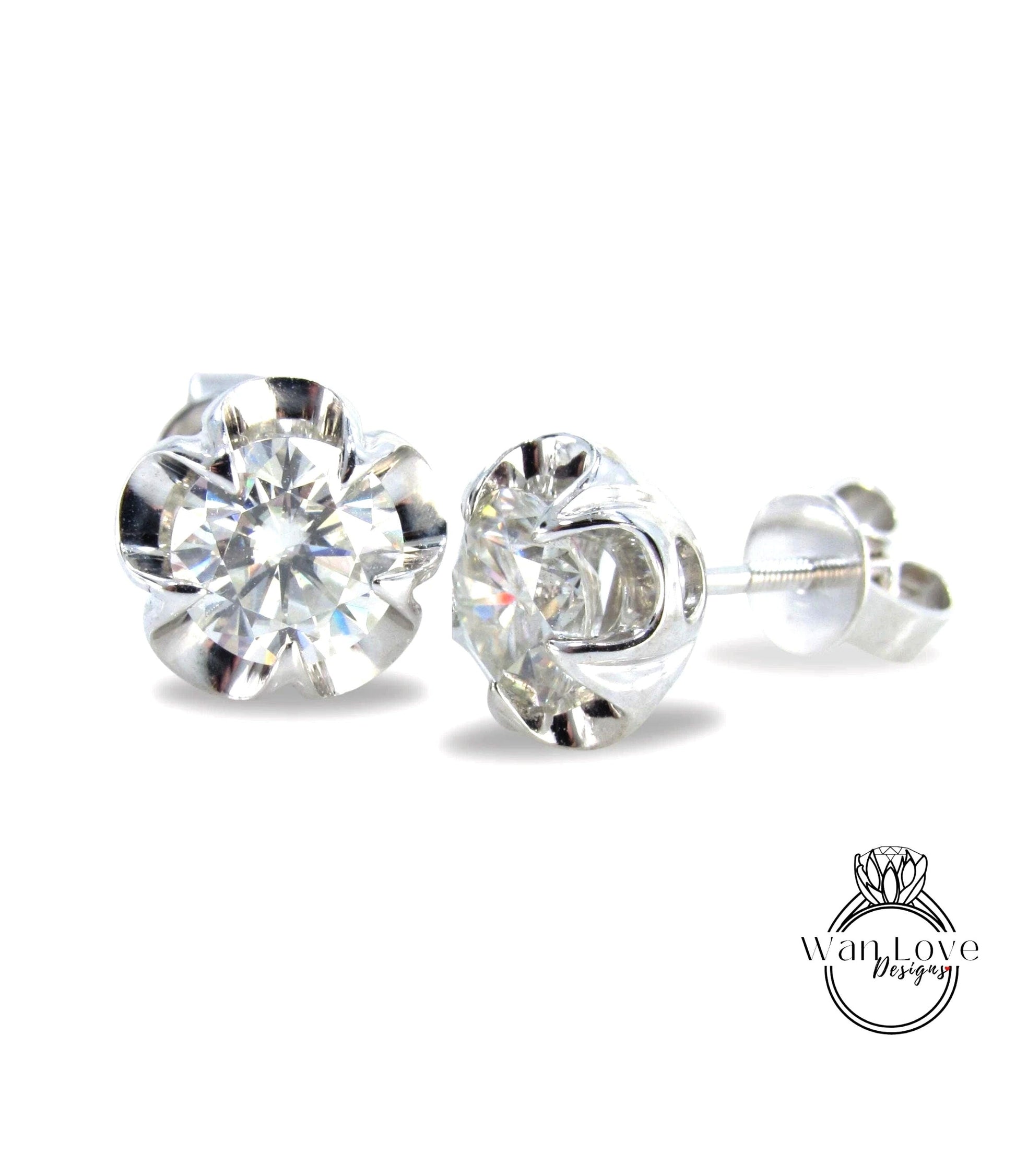 A pair of elegant diamond stud earrings with a clear gemstone set in a silver metal earring back.