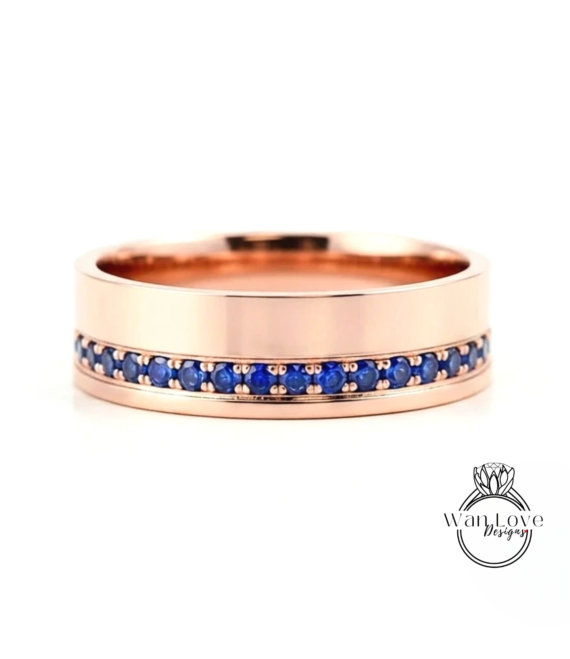 A rose gold ring with a row of blue sapphires set in the band.