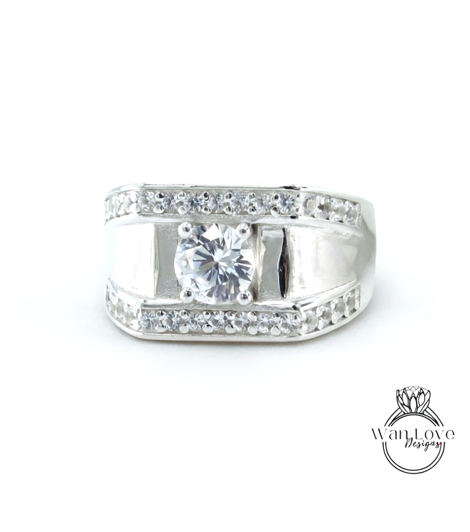 A silver ring with a large central diamond surrounded by smaller diamonds along the band.