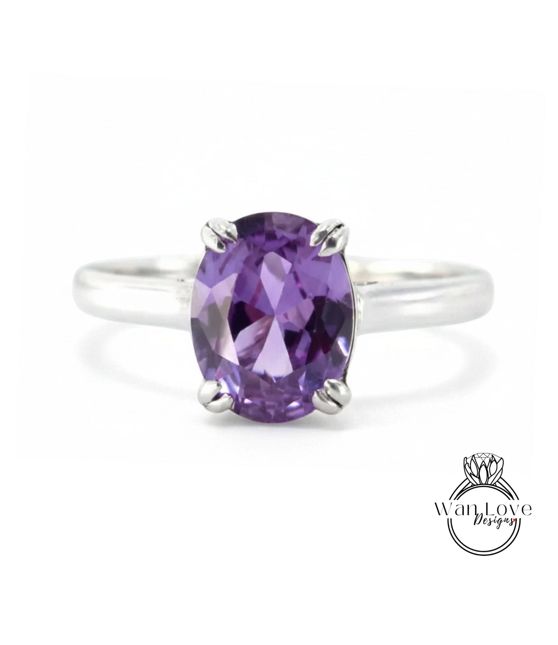 A silver ring with a large oval-shaped purple gemstone, which appears to be a sapphire.
