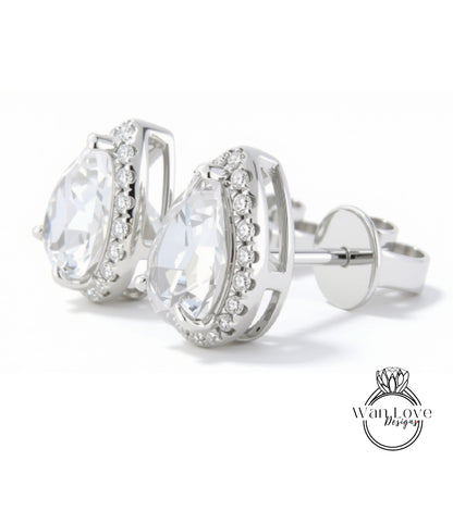 A pair of elegant silver earrings with large, clear gemstones set in a halo-like design.