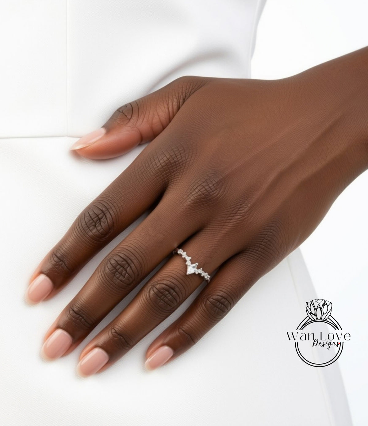 A close-up of a hand wearing a diamond engagement ring.