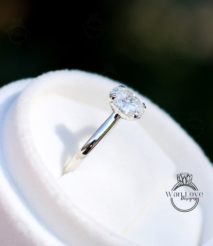 A close-up view of a diamond engagement ring placed on a white velvet cushion.