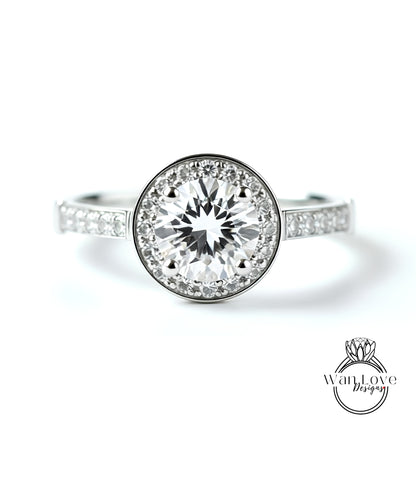 A close-up view of a diamond engagement ring with a large central diamond surrounded by smaller diamonds set in a halo.