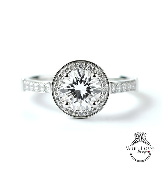 A close-up view of a diamond engagement ring with a large central diamond surrounded by smaller diamonds set in a halo.