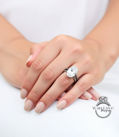 A close-up of a person's hand wearing a large diamond engagement ring.