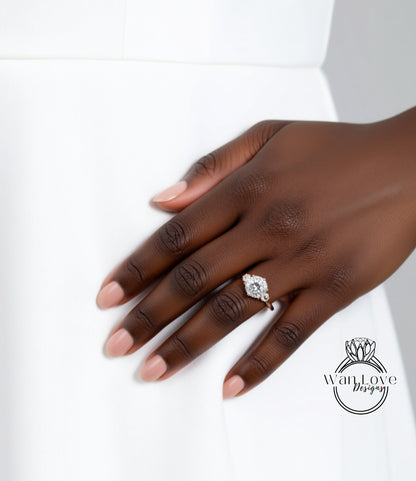 A close-up of a hand wearing a diamond engagement ring, with a white dress visible in the background.