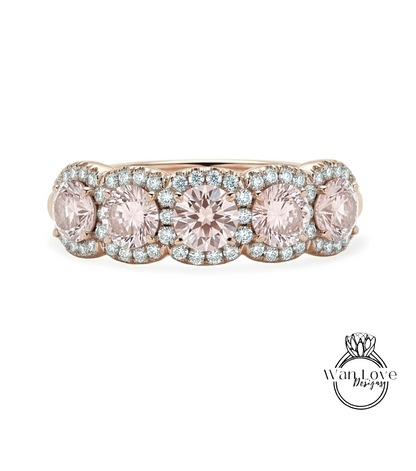 A gold ring with a row of pink gemstones, including diamonds, set in the center.