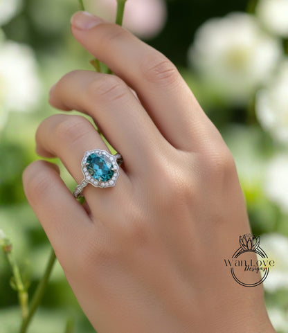 A close-up of a hand wearing a ring with a blue gemstone, set in a silver band.