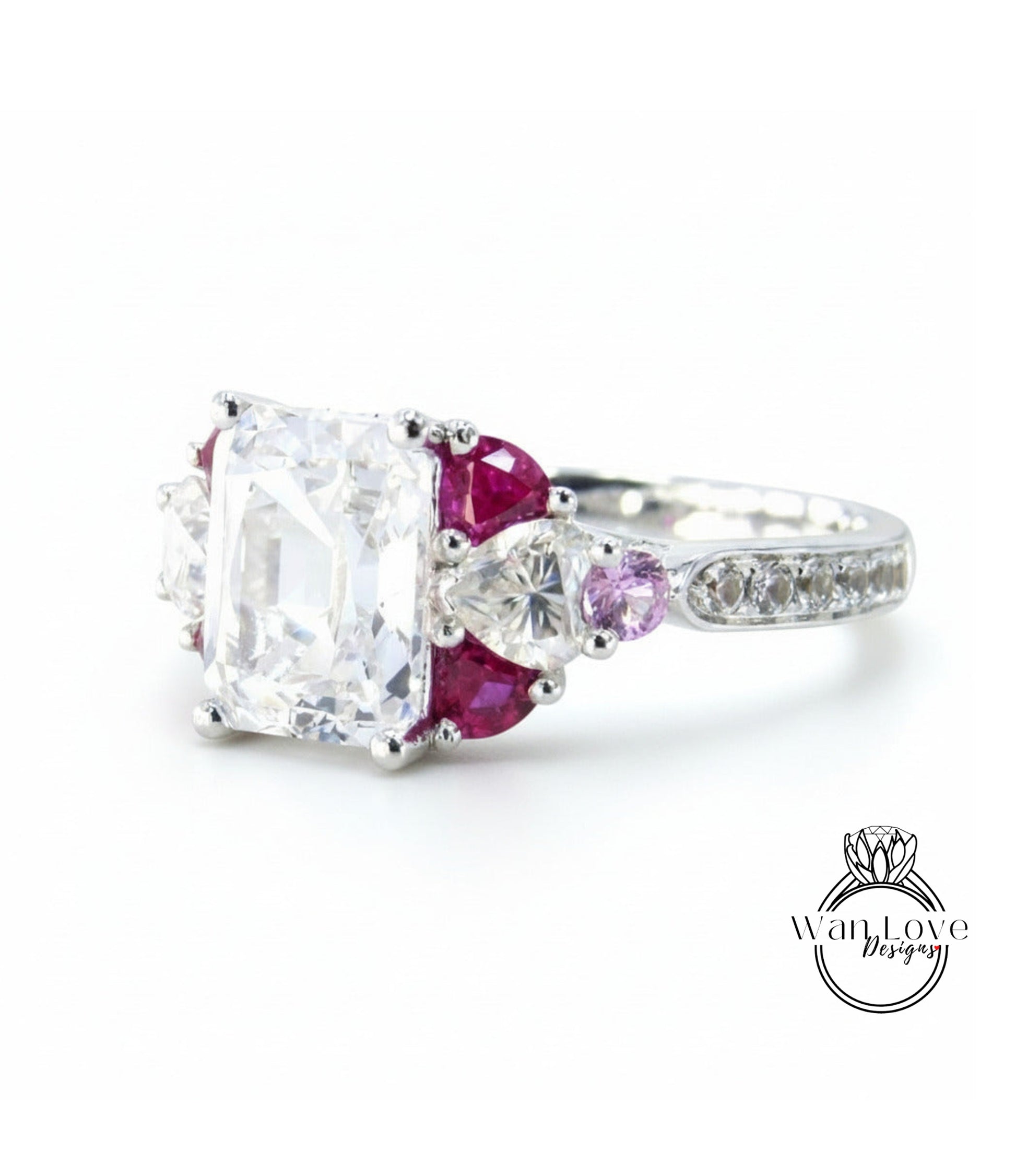 A close-up image of a diamond engagement ring with a large central diamond surrounded by smaller diamonds and gemstones in various colors, including clear, pink, and purple.