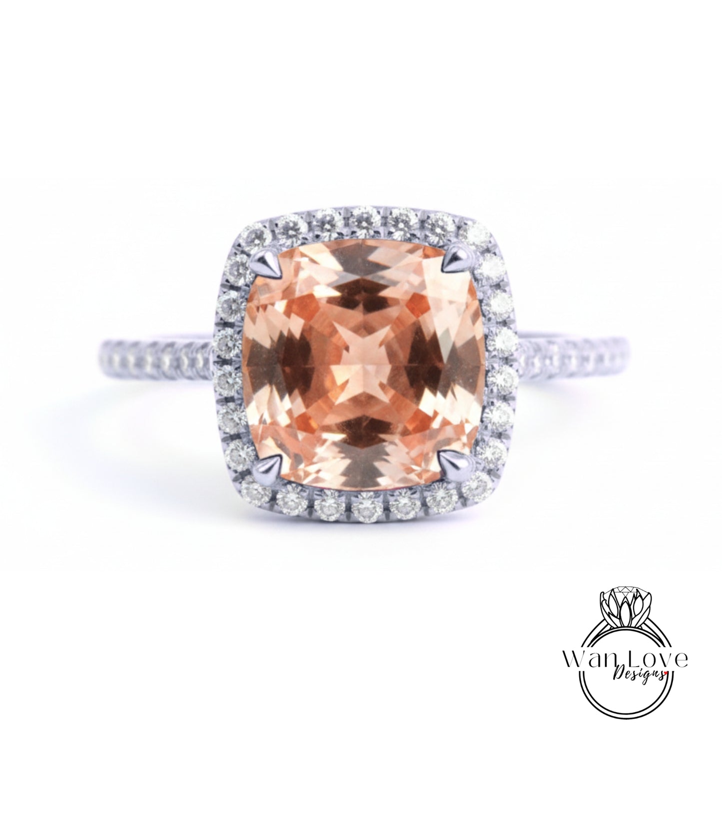 A large, peach-colored gemstone set in a halo of smaller diamonds, with a silver band around the base.