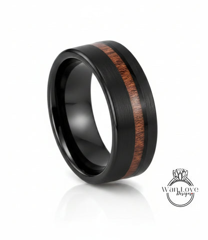 A black ring with a wood grain band in the center, showcasing a unique design.