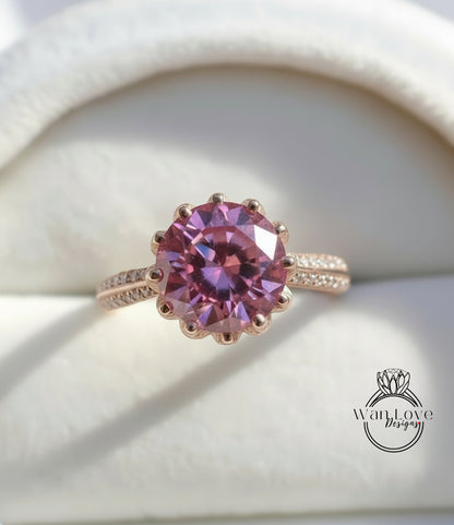 A close-up image of a pink gemstone ring with a large, round center stone surrounded by smaller stones.